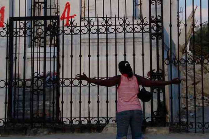 Mujer haitiana arrodillada en oración frente a la Catedral de Puerto Príncipe, capital del país.