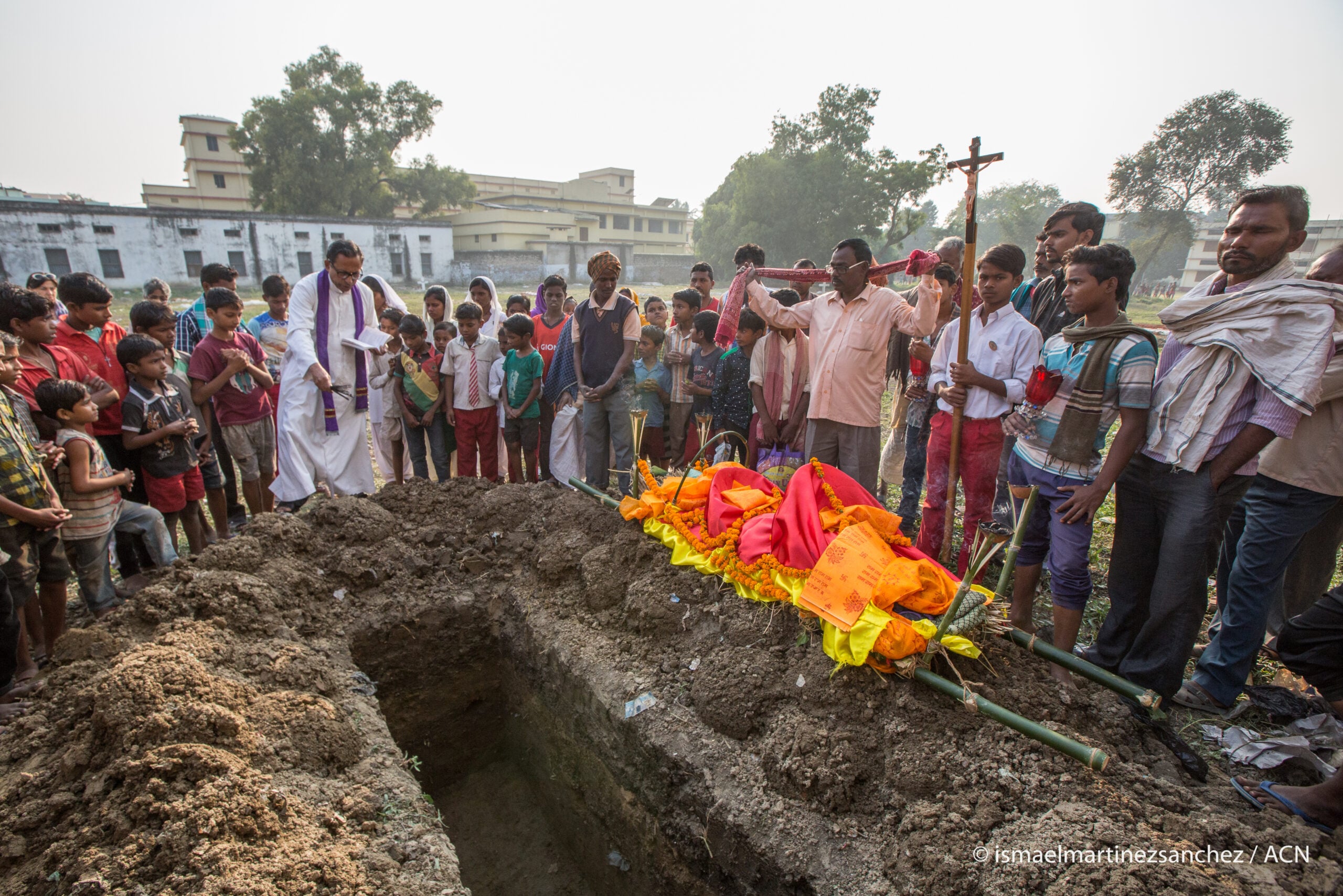 India. Cristianos perseguidos: El sacerdote oficiando el rito en el servicio fúnebre católico en el cementerio del estado de Bihar.